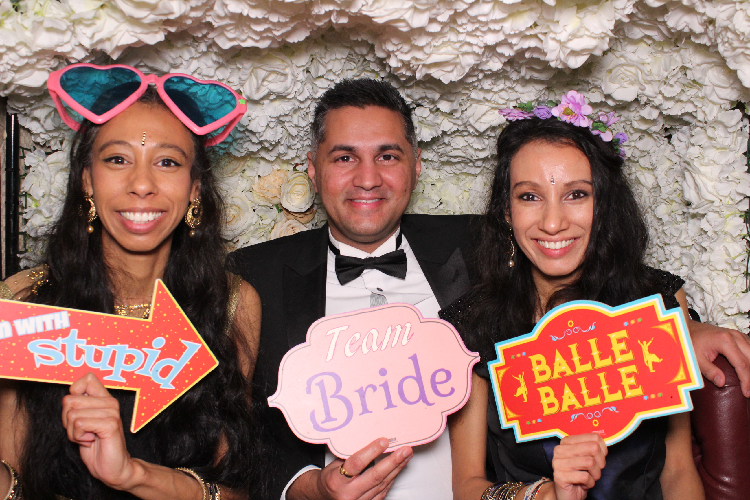Corporate party guests laughing with speech bubble props in a tuk tuk photobooth